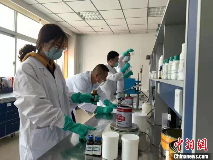 圖為肖菲(前一)帶領團隊研發(fā)水性涂料。(資料圖) 受訪者供圖